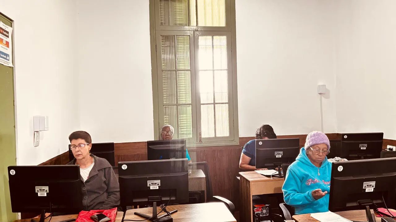 Pessoas idosas aprendendo informática nos computadores do CRI